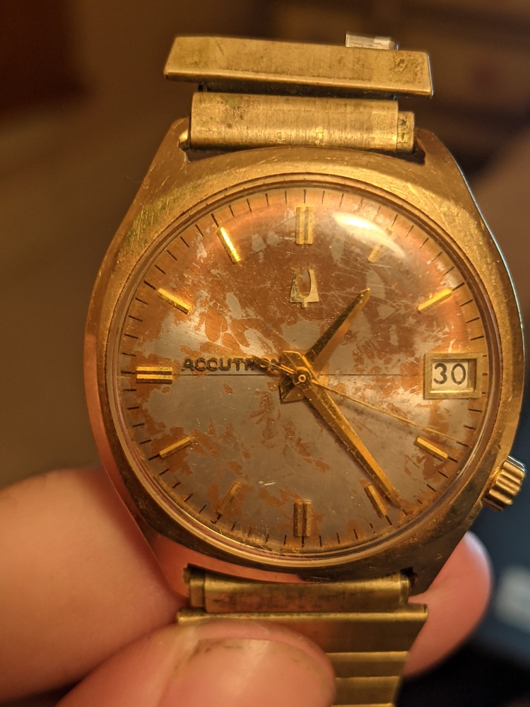 Accutron watch face with Accutron logo to the left, date to the right, and crown to the bottom right